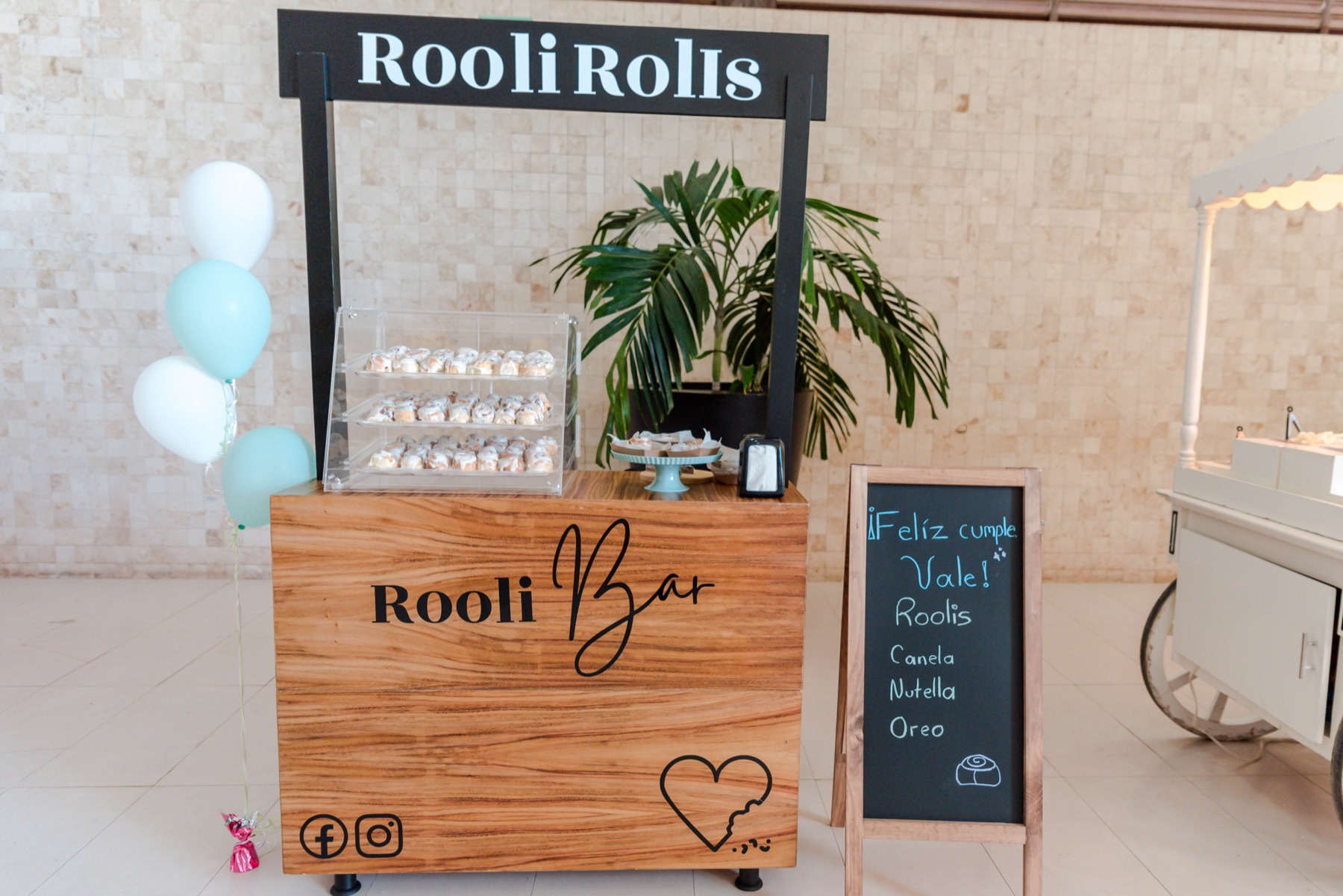 Carrito Rooli Bar montado para un evento, con vitrina de roles y decoración